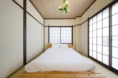 a bedroom with a bed in a room with windows at \u3077\u3075\u304b\u4e80\u6238 in Tokyo