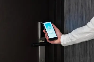 a person holding a cell phone in a door at Prince Smart Inn Ebisu in Tokyo