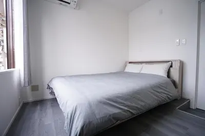a bed in a white room with a large window at ZAITO Tokyo Skytree-Yokokawa II Studio \u5929\u7a7a\u6811\u65c1\u8212\u9002\u578b\u6c11\u5bbf-\u5b85\u4e1c\u6a2aII\u53f7\u5e97 in Tokyo