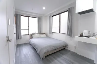 a white bedroom with a bed and two windows at ZAITO Tokyo Skytree-Yokokawa II Studio \u5929\u7a7a\u6811\u65c1\u8212\u9002\u578b\u6c11\u5bbf-\u5b85\u4e1c\u6a2aII\u53f7\u5e97 in Tokyo