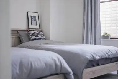 two beds sitting next to a window in a bedroom at ZAITO Tokyo Skytree-Yokokawa II Studio \u5929\u7a7a\u6811\u65c1\u8212\u9002\u578b\u6c11\u5bbf-\u5b85\u4e1c\u6a2aII\u53f7\u5e97 in Tokyo