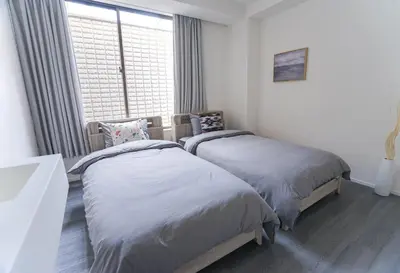two beds in a room with a window at ZAITO Tokyo Skytree-Yokokawa II Studio \u5929\u7a7a\u6811\u65c1\u8212\u9002\u578b\u6c11\u5bbf-\u5b85\u4e1c\u6a2aII\u53f7\u5e97 in Tokyo