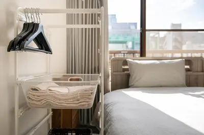 a bedroom with a bed with a basket next to a window at ZAITO Tokyo Skytree-Yokokawa II Studio \u5929\u7a7a\u6811\u65c1\u8212\u9002\u578b\u6c11\u5bbf-\u5b85\u4e1c\u6a2aII\u53f7\u5e97 in Tokyo