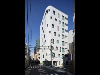 a tall white building on a city street at 9h nine hours Ningyocho in Tokyo