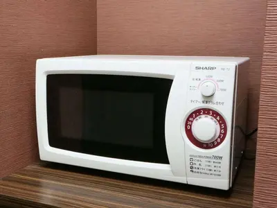a white microwave sitting on top of a counter at APA Hotel Shimbashi Toranomon in Tokyo
