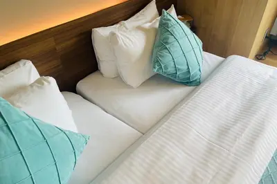 two beds with pillows on them in a hotel room at ICHIYU HOTEL ASAKUSA in Tokyo