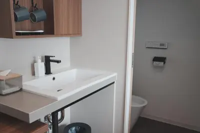 a bathroom with a white sink and a toilet at ICHIYU HOTEL ASAKUSA in Tokyo