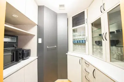 a kitchen with white cabinets and a door at NY Cottage\uff08\u30b3\u30c6\u30fc\u30b8\uff09 in Tokyo