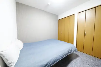 a bedroom with a bed and wooden cabinets at NY Cottage A in Tokyo
