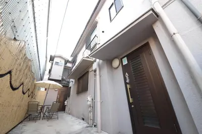an alley with a door and chairs and an umbrella at NY Cottage A in Tokyo