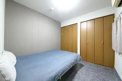 a bedroom with a bed and wooden cabinets at NY Cottage A in Tokyo