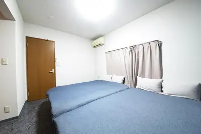 a bedroom with a blue bed and a window at NY Cottage A in Tokyo