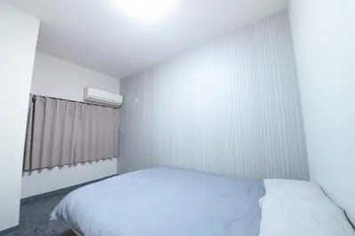 a white bedroom with a bed and a window at NY Cottage B in Tokyo