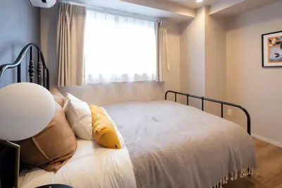 a bedroom with a bed with a large window at Ken's Place麻布East in Tokyo