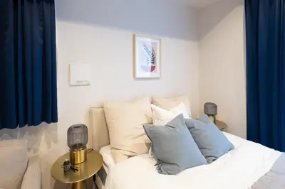a bedroom with a white bed with blue curtains at Ken's Place麻布East in Tokyo