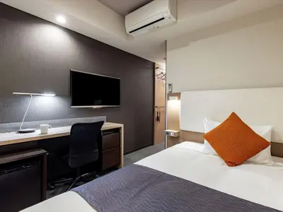 a hotel room with a bed and a desk and a tv at Tokyu Stay Shimbashi - Ginza area in Tokyo