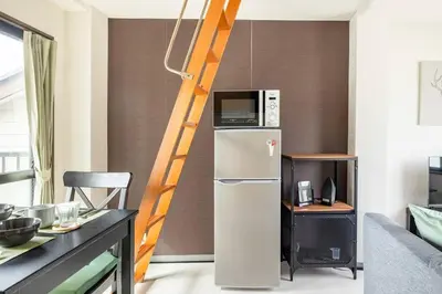a kitchen with a refrigerator with a microwave on top of it at PAPA301 in Tokyo
