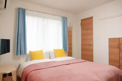 a bedroom with a large bed and a window at Triphome Tateishi New open/2 single beds/big table/300M WiFi in Tokyo