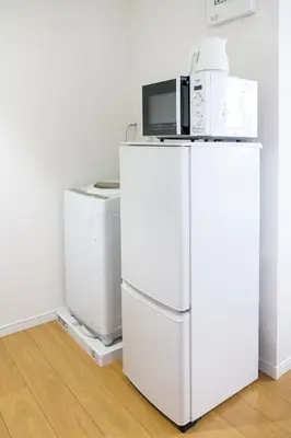 a microwave on top of a white refrigerator at Triphome Tateishi New open/2 single beds/big table/300M WiFi in Tokyo