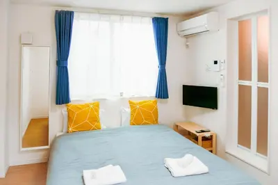 a small bedroom with a blue bed and a window at Triphome Tateishi New open/2 single beds/big table/300M WiFi in Tokyo