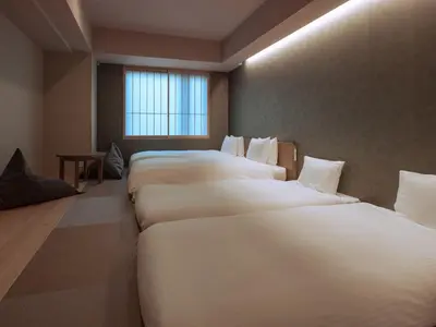 a row of white beds in a room with a window at MIMARU Tokyo Ikebukuro in Tokyo