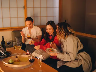 a group of people sitting at a table in a restaurant at MIMARU SUITES Tokyo Asakusa in Tokyo