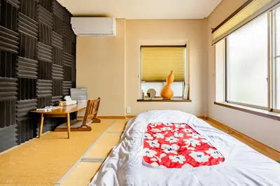 a bedroom with a bed and a desk and a window at Dat's house in Tokyo