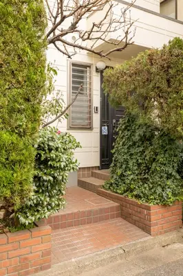 a house with a brick walkway leading to a black door at Dat's house in Tokyo