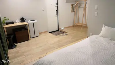 a bedroom with a bed and a wooden floor at Leisure hotel \u4e2d\u91ce in Tokyo