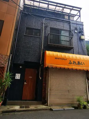 a building with two garage doors and a balcony at Leisure hotel \u4e2d\u91ce in Tokyo