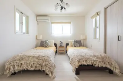 two beds in a room with white walls and windows at \u821e\u6d5c1\u8ed2\u5bb6\u8cb8\u5207\u30fc\u6700\u592710\u540d\u69d8\u4e00\u99d0\u8eca\u5834\u4ed8\u304dMaihama rent-a-house in Urayasu