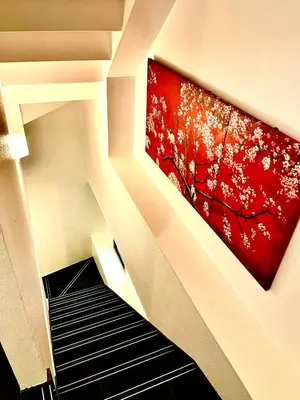 a painting hanging on a wall next to a staircase at AYA Hotel in Tokyo