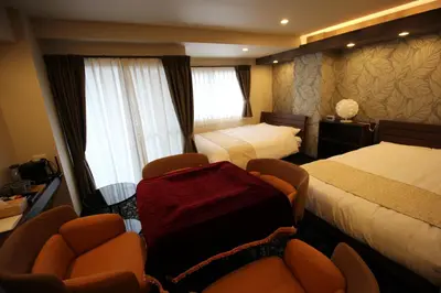 a hotel room with two beds and two chairs at AYA Hotel in Tokyo