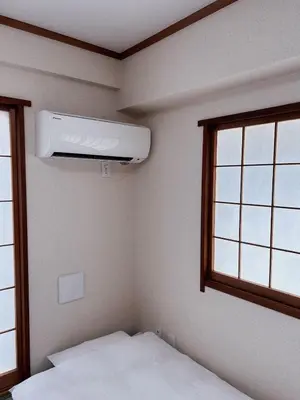 a bedroom with a white air conditioner on the wall at Shiki no Sai Asakusa in Tokyo