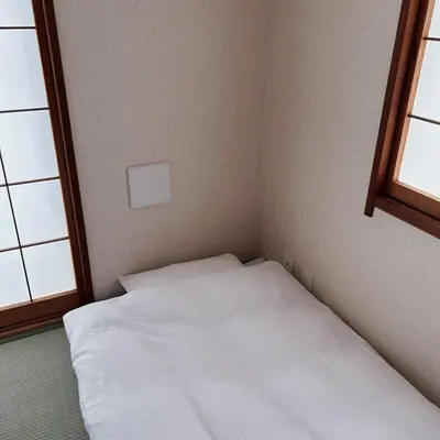 a white bed in a room with two windows at Shiki no Sai Asakusa in Tokyo