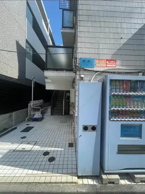 a refrigerator in front of a building with drinks at Jellynehouse\u65b0\u5927\u4e45\u4fdd in Tokyo