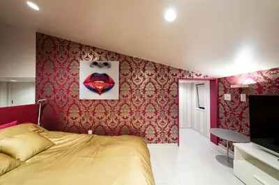 a bedroom with a bed and red wallpaper at La Krasse Skytree - Vacation STAY 12839 in Tokyo