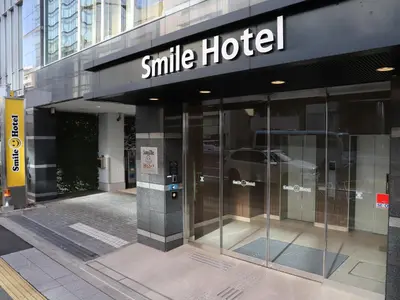 a smile hotel sign on the side of a building at Smile Hotel Shinagawa Sengakuji Ekimae in Tokyo