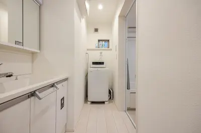 a small white kitchen with a refrigerator in it at Senjyu House in Tokyo