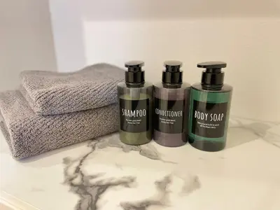 three bottles of shampoo and conditioner on a bathroom counter at Senjyu House in Tokyo