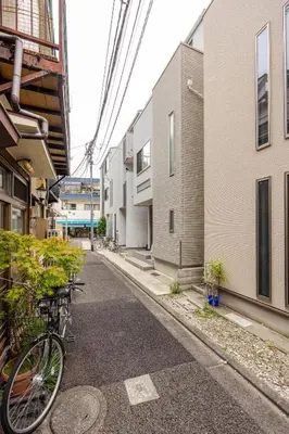a bike parked on a street between two buildings at Senjyu House in Tokyo