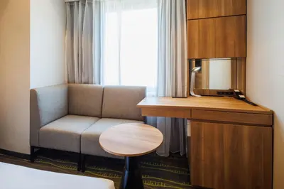 a room with a couch and a desk and a chair at JR-East Hotel Mets Shibuya in Tokyo