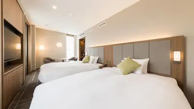 two beds in a hotel room with white sheets at JR-East Hotel Mets Mejiro in Tokyo