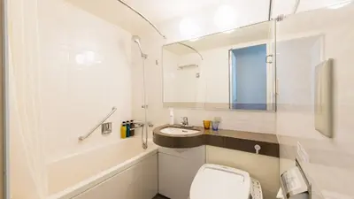 a white bathroom with a sink and a toilet at JR-East Hotel Mets Mejiro in Tokyo