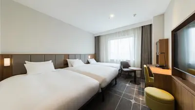 a hotel room with two beds and a flat screen tv at JR-East Hotel Mets Mejiro in Tokyo