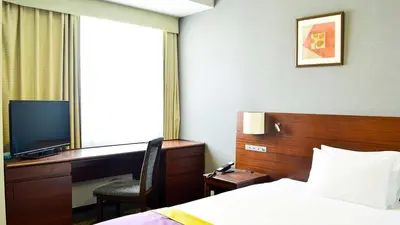 a hotel room with a bed and a desk and a television at JR-East Hotel Mets Komagome in Tokyo