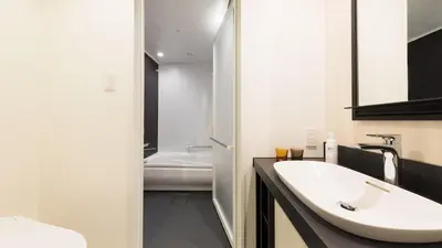 a bathroom with a white sink and a bath tub at JR East Hotel Mets Premier Akihabara in Tokyo