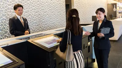 a man and a woman standing at a counter in a store at JR East Hotel Mets Premier Akihabara in Tokyo