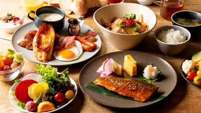 a wooden table with plates of food on it at JR East Hotel Mets Premier Gotanda in Tokyo