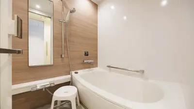 a bathroom with a tub and a toilet and a sink at JR East Hotel Mets Premier Gotanda in Tokyo